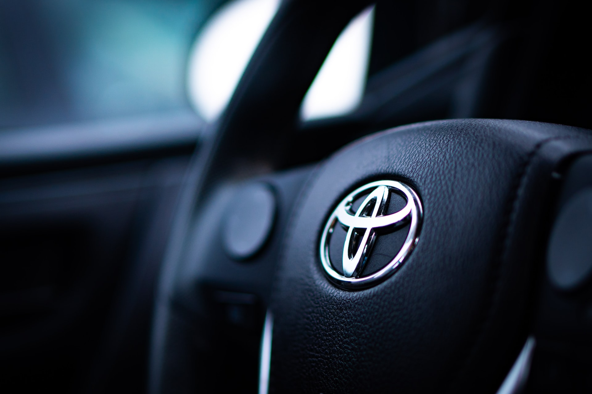 A close-up of a black Toyota steering wheel inside a vehicle