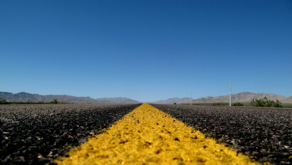 A close-up shot of the yellow paint on a desert road